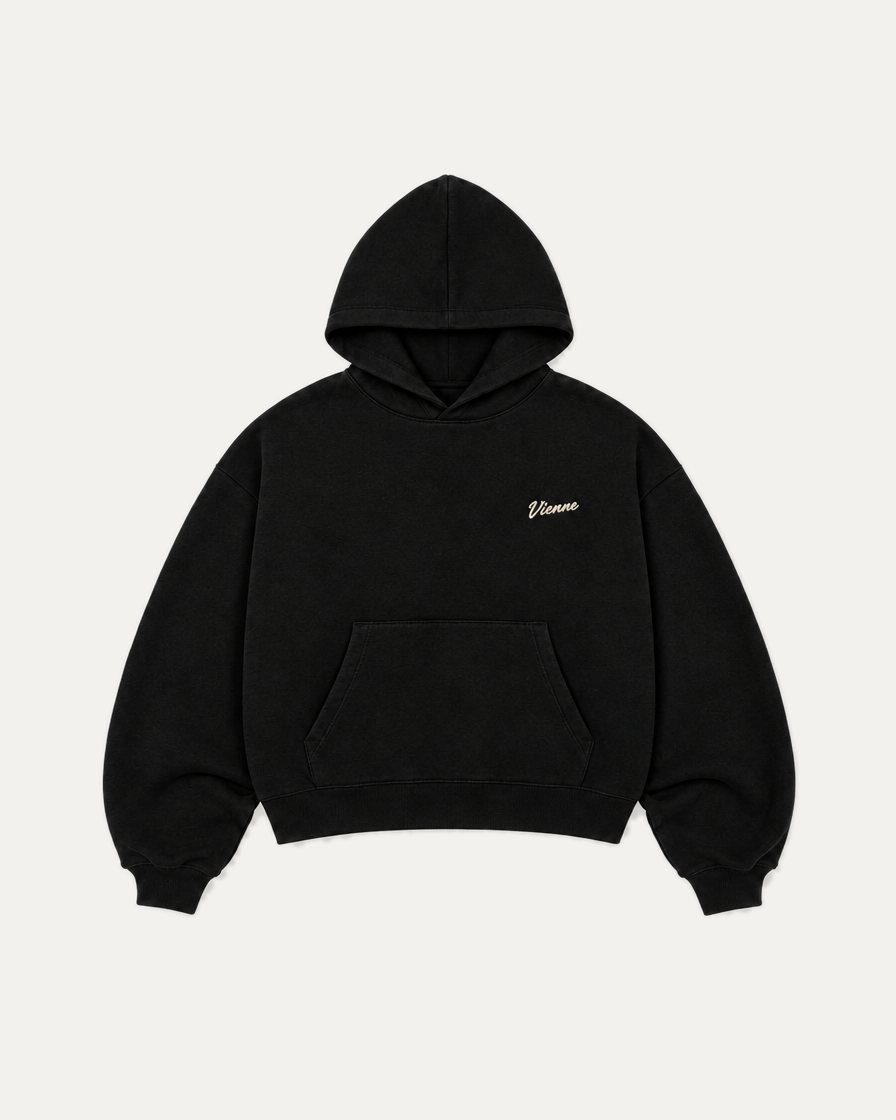 Concept image: black Signé Hoodie with a small cream Vienne script on the left chest, front