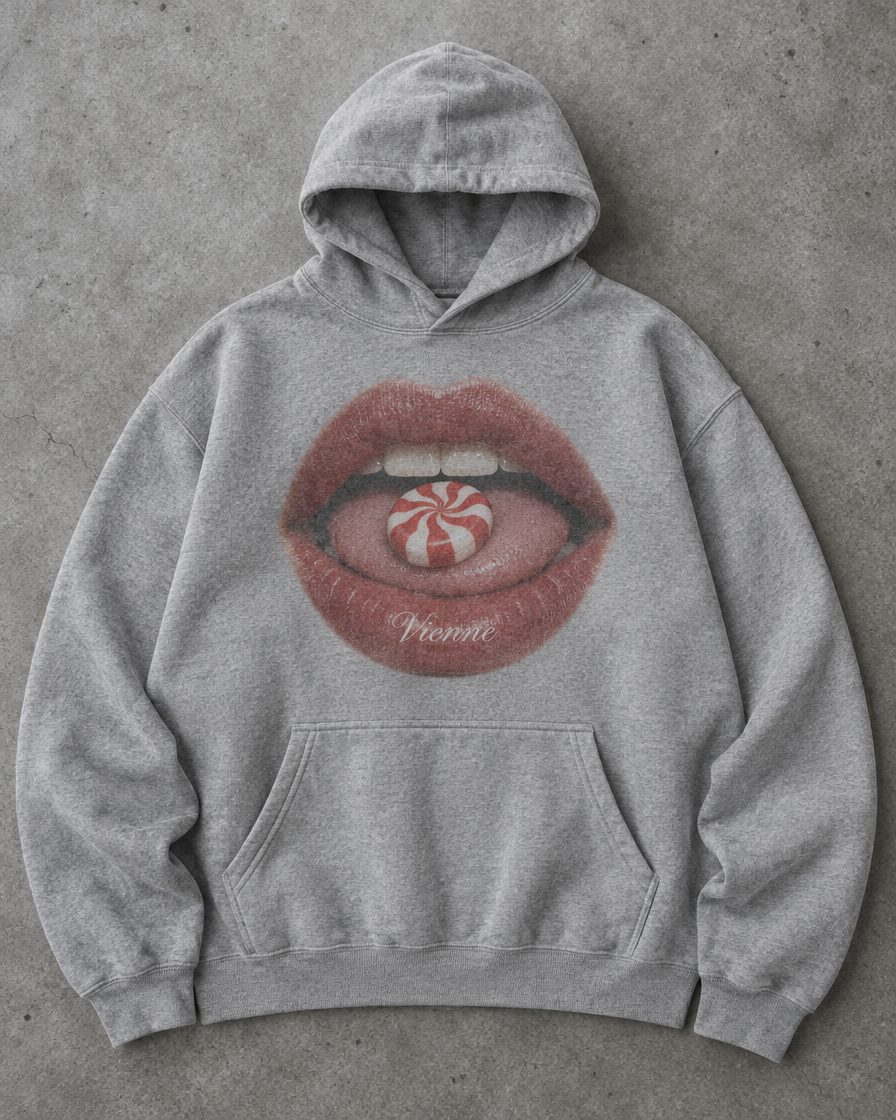 Concept render: heather grey hoodie with a photo print of lips holding a peppermint candy, Vienne on the lower lip
