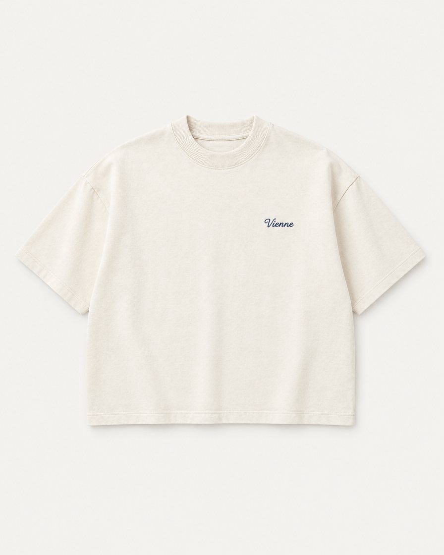 Concept render: cream boxy tee with a small navy Vienne script on the chest