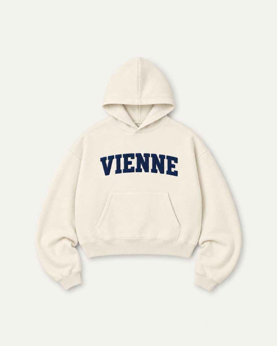 Concept render: cream hoodie with VIENNE in navy chenille letters across the chest