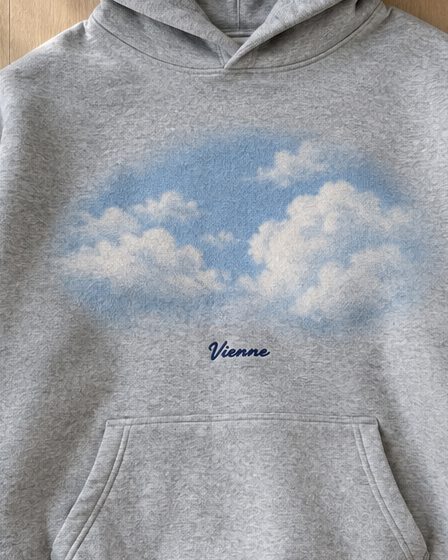 Concept render: heather grey hoodie with an airbrushed sky and clouds graphic, close up of the detail